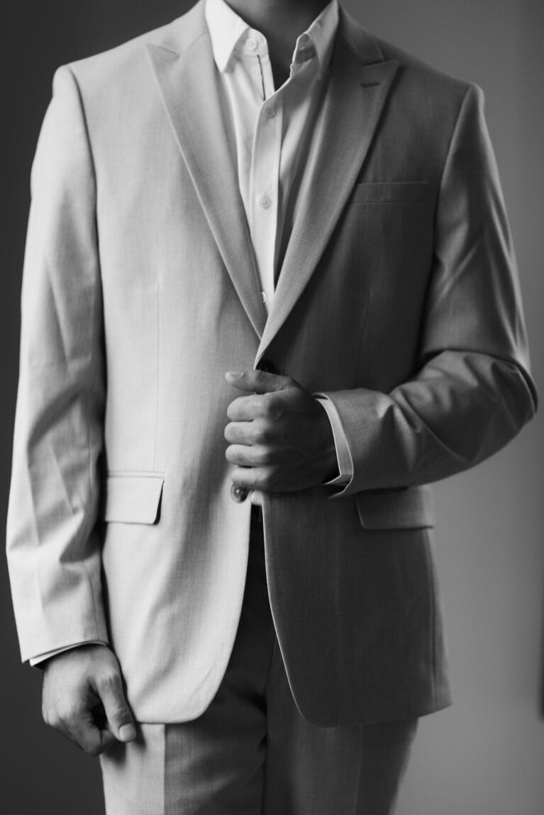Groom buttoning his jacket