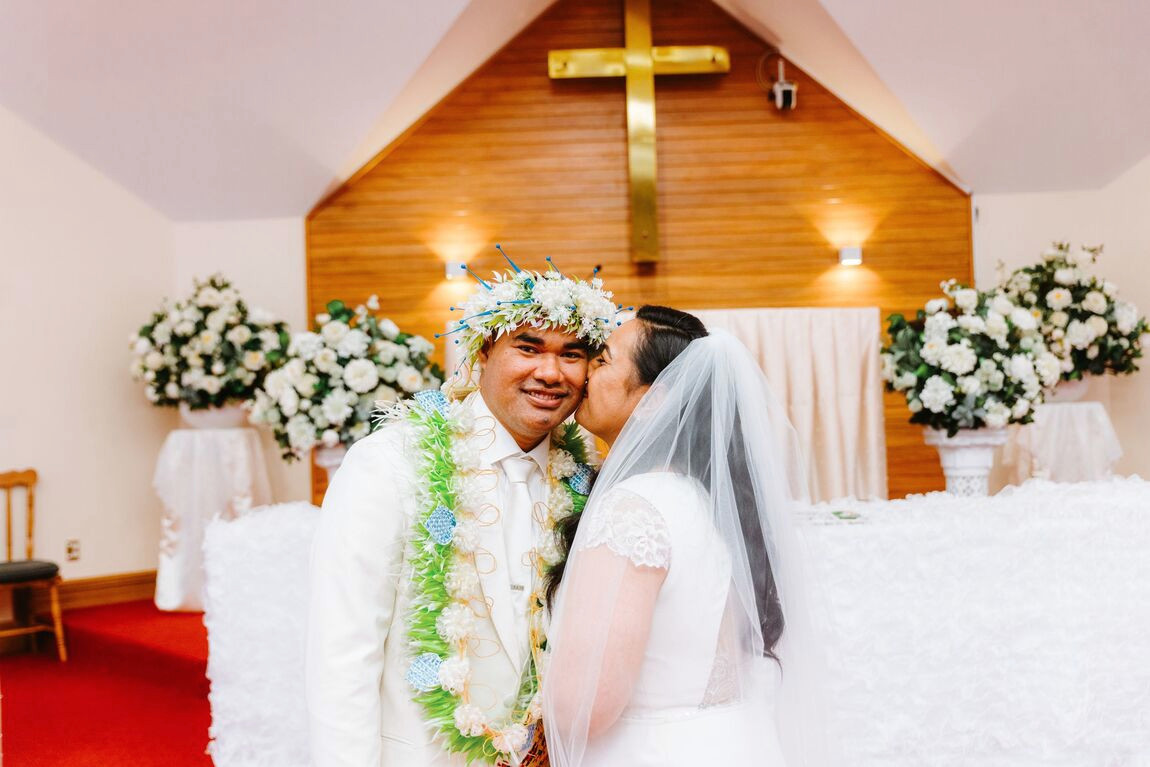 A couple sharing a kiss at the front of a church